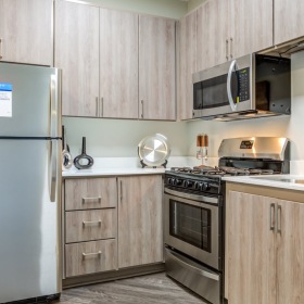  a kitchen with wood cabinets and stainless steel applicances