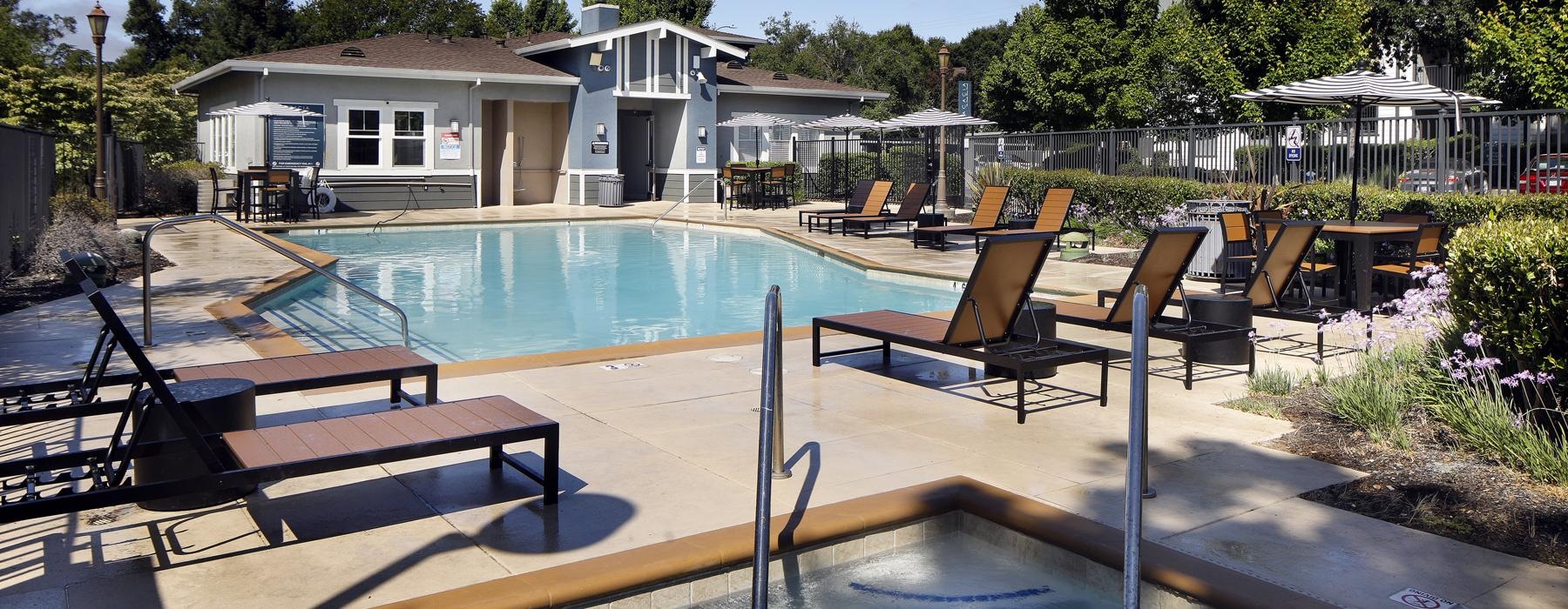 a swimming pool with lounge chairs and tables