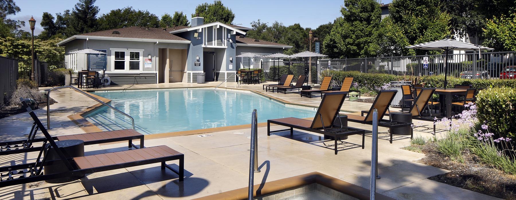 a swimming pool with lounge chairs and tables