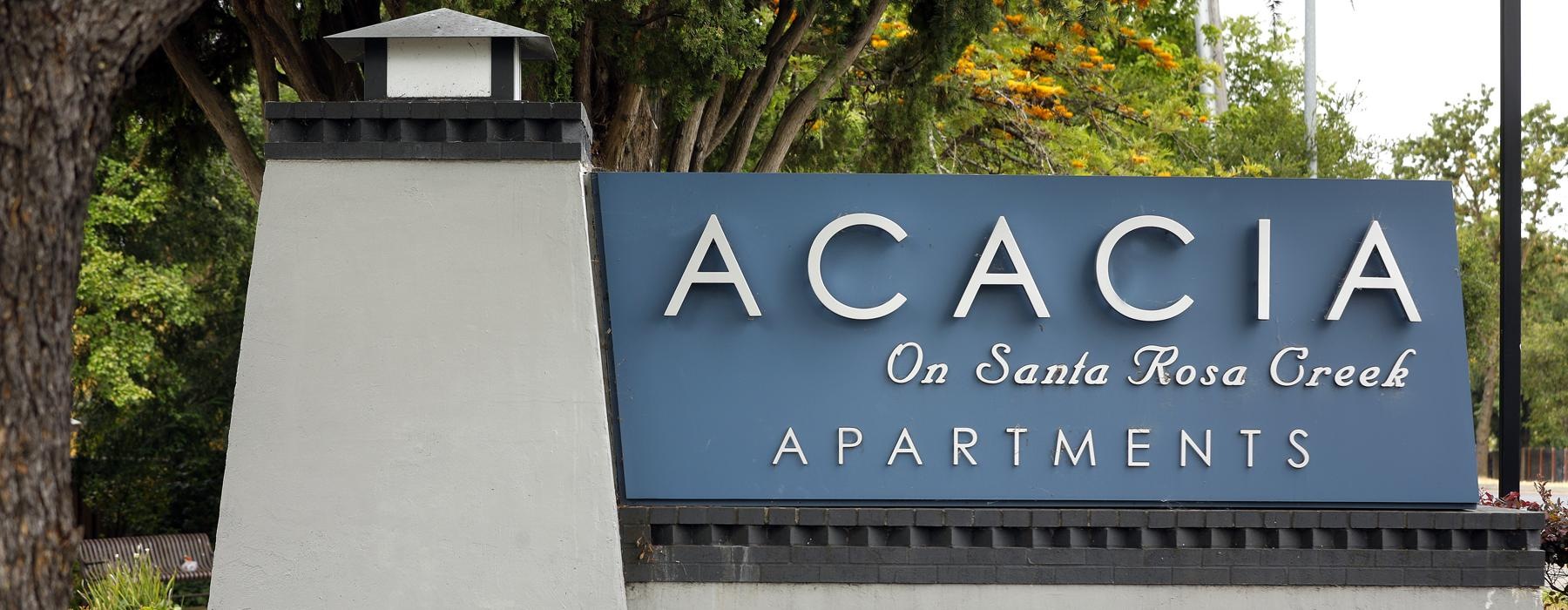 a sign on a building that reads acacia apartments