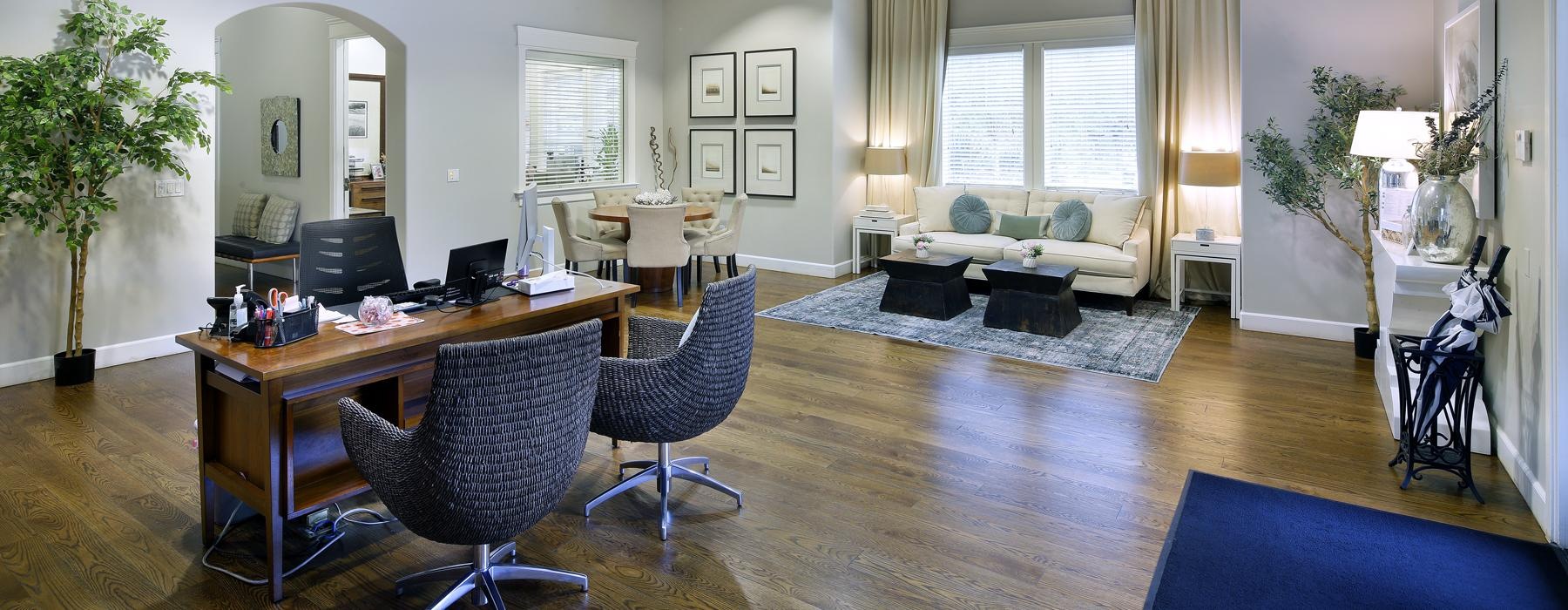 a large lobby room with a table and chairs and large windows